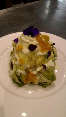 a white plate with a salad on a table at Hotel Meridiana in Bellano
