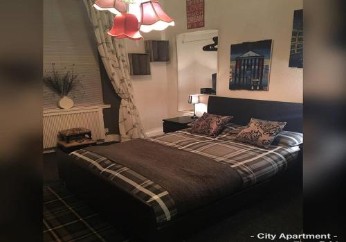 1 dormitorio con cama y lámpara de araña en Glasgow City Centre Apartment en Glasgow