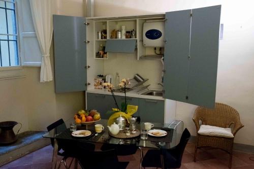 eine Küche mit einem Tisch und eine Küche mit blauen Schränken in der Unterkunft Bargello121 in Florenz