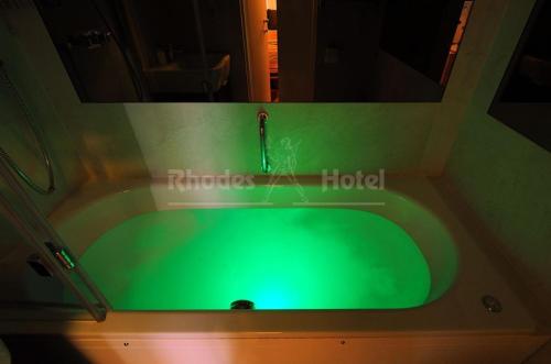 a green tub with a faucet in a bathroom at Rhodes Hotel in London
