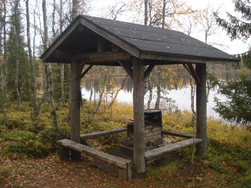 a wooden shelter in the middle of a forest at Hakamajat Cottages in Syöte