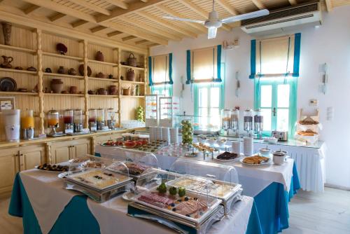 una línea de buffet con mesas con comida. en Poseidon Hotel Suites, en Mykonos ciudad