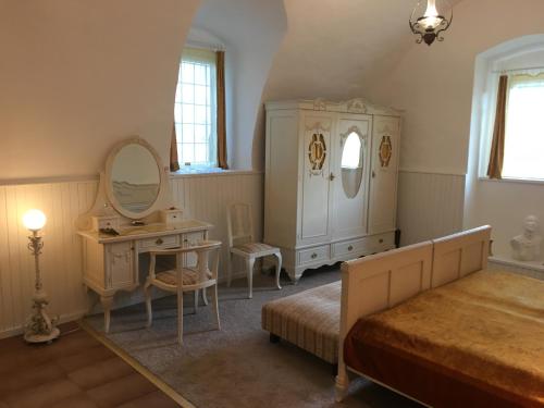 a bedroom with a bed and a desk and a dresser at Gothic House Apartments in Kremnica