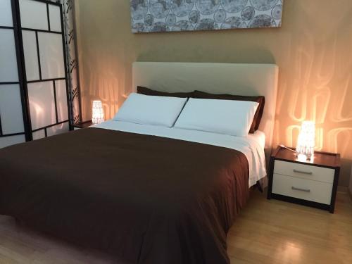 カターニアにあるLa Casa del Nespoloのベッドルーム1室(ベッド1台、ナイトスタンド、ランプ付)