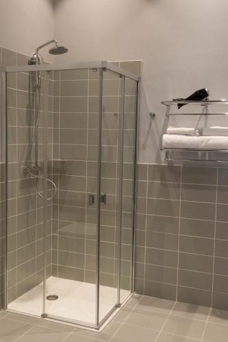a shower with a glass door in a bathroom at The Originals Boutique, Hôtel des Sources, Nevers Nord in Pougues-les-Eaux