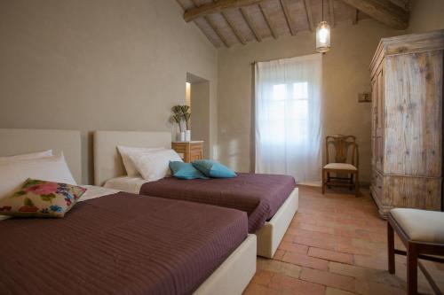 um quarto com 2 camas, uma cadeira e uma janela em Villa La Colognola em Magione