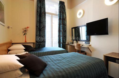 Un pat sau paturi într-o cameră la Rhodes Hotel