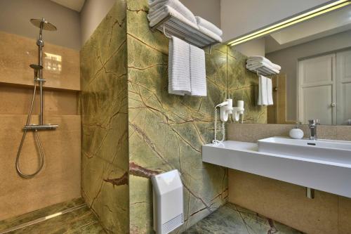 een badkamer met een wastafel en een spiegel bij Mint Suite No2 in Valletta