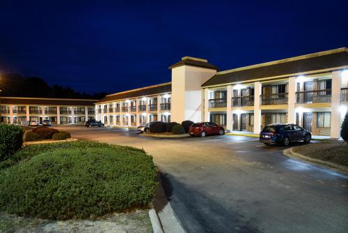 a large building with cars parked in a parking lot at Quality Inn & Suites Fayetteville I-95 in Fayetteville