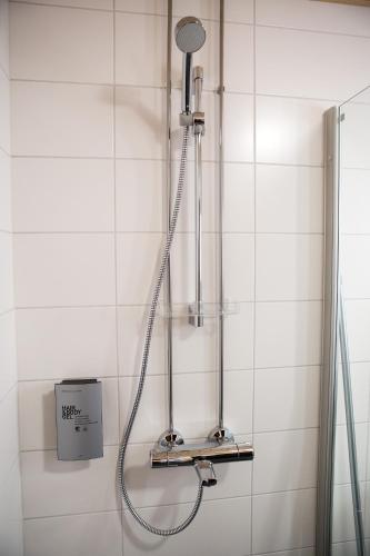 a shower in a white tiled bathroom at Antintorni Apartment 2 in Pori