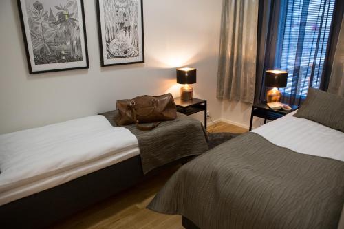 una habitación de hotel con 2 camas y un bolso en la cama en Antintorni Apartment 2, en Pori