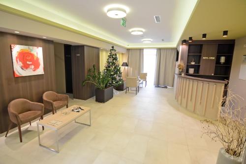 a lobby with chairs and a christmas tree in a building at Hotel Gallus in Sesvete
