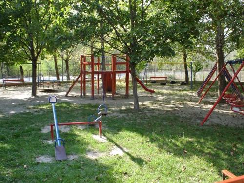 a park with a playground with a red swing at Oasi in Kato Loutraki