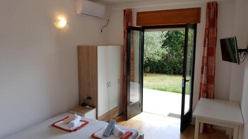 a room with a door open to a yard at Apartments Adriatic in Selce