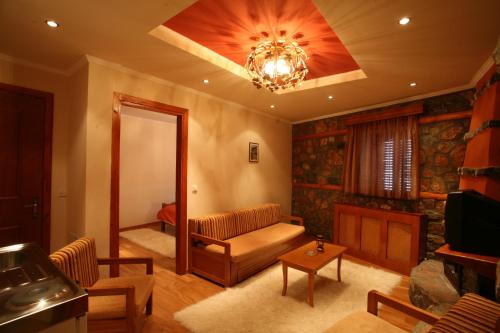a living room with a couch and a chandelier at Exohiko in Palaios Agios Athanasios