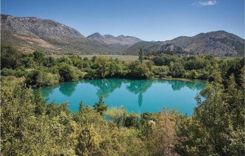 a blue lake with trees and mountains in the background at Apartmani Galić in Ploče