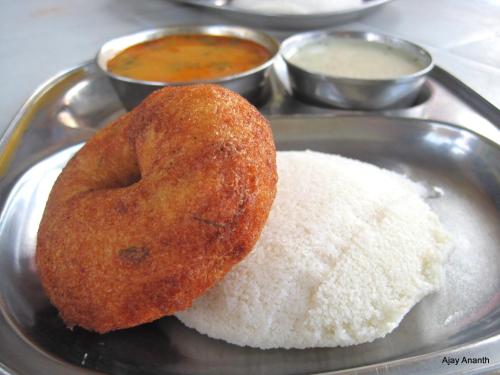 two donuts sitting on a plate with rice at Rosepark Residency in Ooty