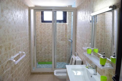 y baño con ducha, aseo y lavamanos. en Kakatar Family Residence , Yoff, en Dakar