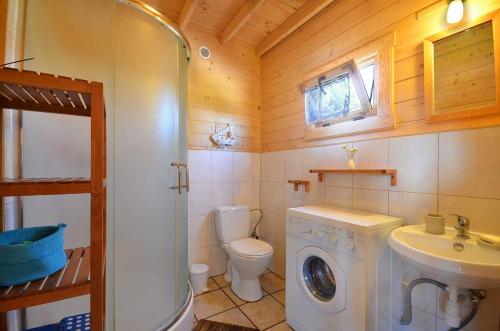 a bathroom with a washing machine and a sink at Zagroda in Sarbinowo