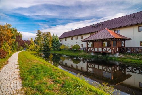 a building next to a river next to a building at Hotel Karczyce in Karczyce