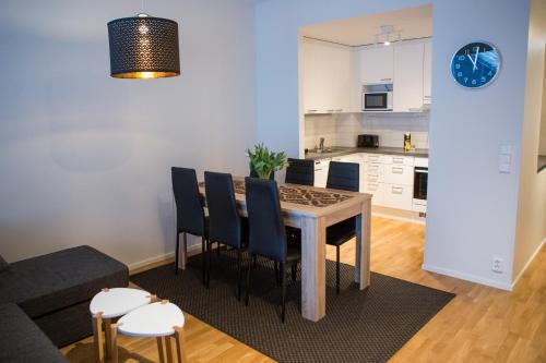 a living room with a table and chairs and a kitchen at Antintorni Apartment 7 in Pori