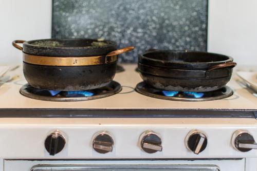 two pans sitting on top of a stove at Pousada Chão de Minas Ouro Preto in Ouro Preto