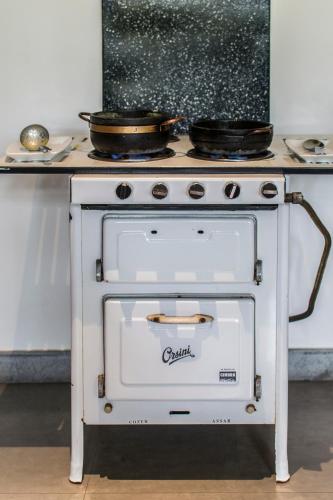 a white stove with two pans on top of it at Pousada Chão de Minas Ouro Preto in Ouro Preto