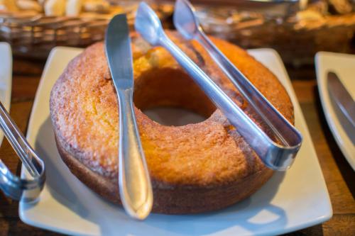 a bundt cake with two spoons on top of it at Pousada Chão de Minas Ouro Preto in Ouro Preto