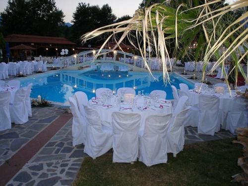 a group of tables and chairs in front of a pool at Oasi in Kato Loutraki