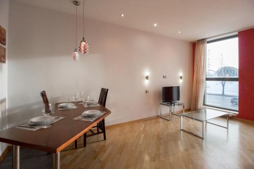 uma sala de jantar com uma mesa e uma televisão em Riga City Center Apartment em Riga