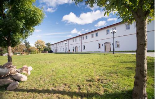 a large white building with trees in the grass at Hotel Karczyce in Karczyce