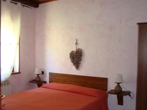 una camera da letto con un letto con un cuore sul muro di Agriturismo Centuria a San Pio delle Camere