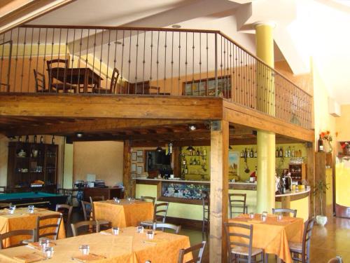 un ristorante con tavoli e sedie e un balcone di Agriturismo Centuria a San Pio delle Camere
