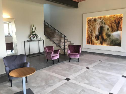 a room with chairs and a painting of a horse at Hotel Karczyce in Karczyce