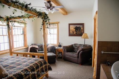 a bedroom with a bed and a couch and a chair at Second Wind Country Inn in Ashland