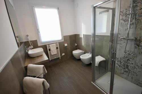a bathroom with two toilets and a glass shower at Pove 2.4 Hotel in Pove del Grappa