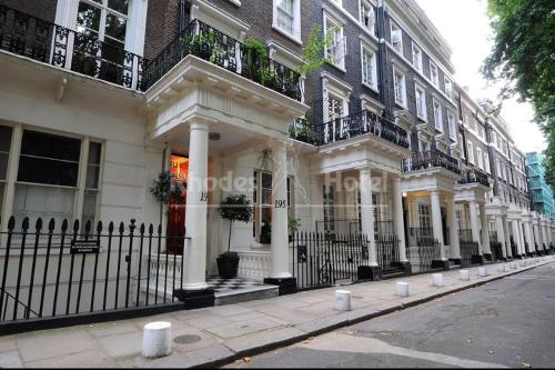 a building with white columns and balconies on a street at Rhodes Hotel in London