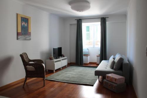 a living room with a couch and a chair at Travellers Pearl by Storytellers in Funchal
