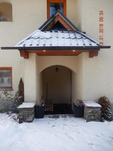 a house with snow on the roof of it at U Hanki in Biały Dunajec