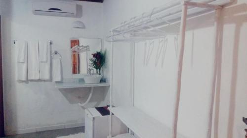 a white bathroom with a sink and a mirror at Pousada João Maria in Trancoso