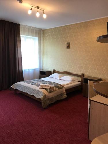 a bedroom with a large bed and a window at Motel Kurortnyy & SPA in Shklo
