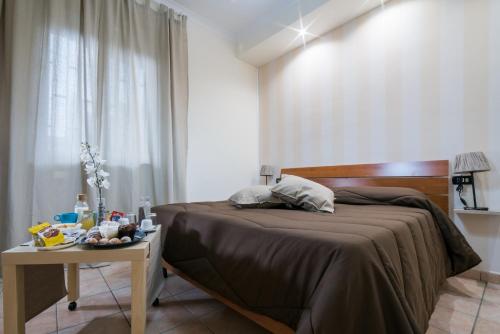 エルコラーノにあるB&B del Soleのベッドルーム1室(ベッド1台、テーブル、食べ物付)