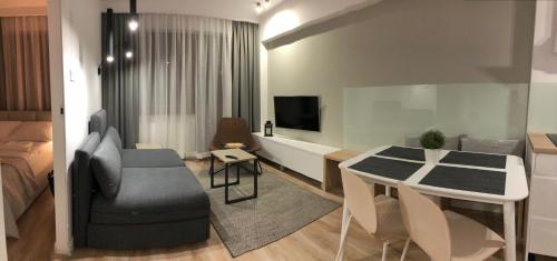 クリニツァ・ズドルイにあるApartament Comfort Zoneのリビングルーム(テーブル付)、ベッドルーム(ベッド付)