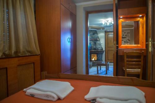 a bedroom with a bed and a mirror with towels at Exohiko in Palaios Agios Athanasios
