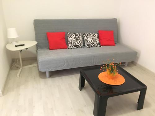 sala de estar con sofá gris y almohadas rojas en Sole e Luna, en Trapani