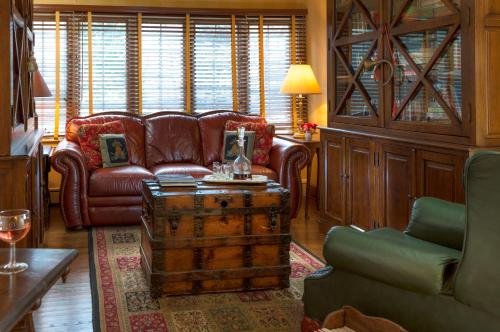 a living room with a leather couch and a table at The Yellow House on Plott Creek in Waynesville