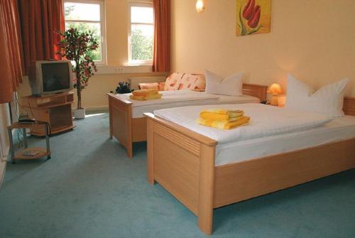 a large bedroom with two beds and a television at Hotel Kubrat an der Spree in Berlin