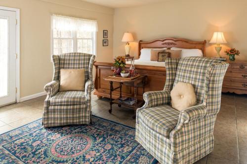 a bedroom with two chairs and a bed at The Yellow House on Plott Creek in Waynesville