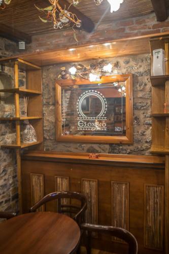 a dining room with a table and a tv on a wall at Exohiko in Palaios Agios Athanasios