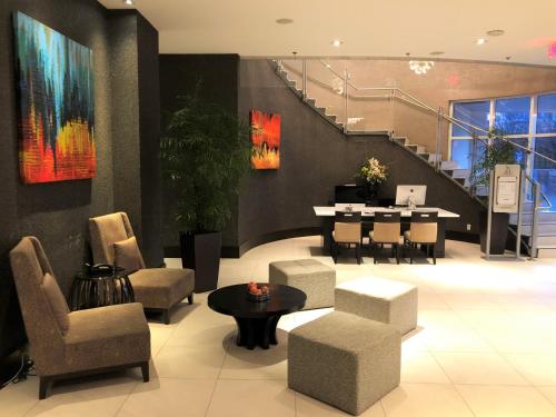 a lobby with chairs and a table and stairs at Pinnacle Hotel at the Pier in North Vancouver